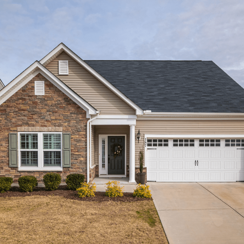 Front of rancher with beige colored dutch lap siding.