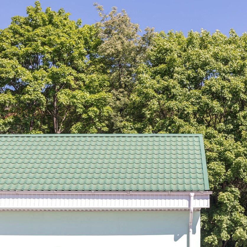 White gutters with white downspout and green roof.